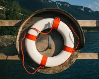 white and red inflatable ring on brown wooden dock during daytime