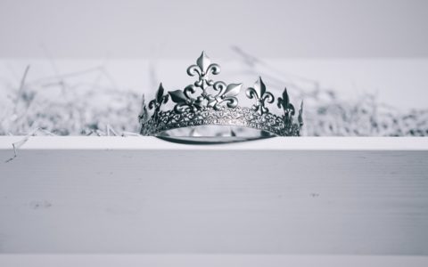 silver-colored crown on top of white wood