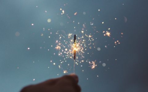 person holding lighted sparklers