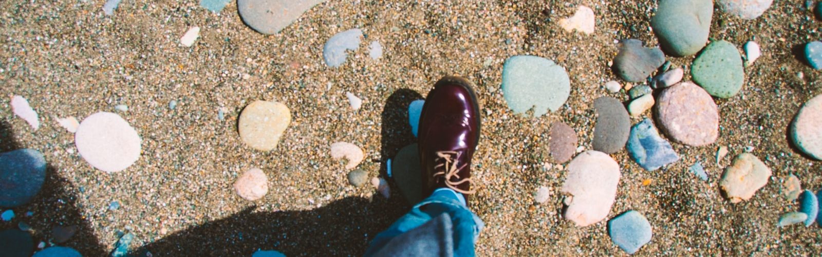 person showing unpaired maroon leather shoe