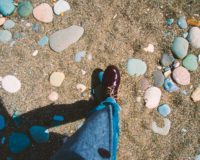 person showing unpaired maroon leather shoe