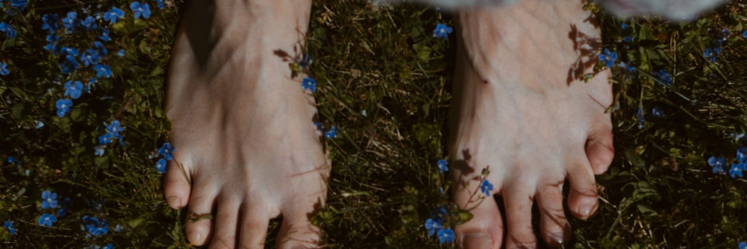 persons feet on green grass