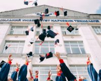 group of fresh graduates students throwing their academic hat in the air