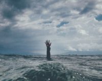 photo of person reach out above the water
