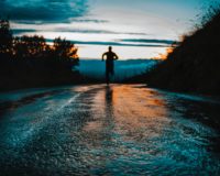 silhouette photo of a person running on road