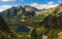 lake in the middle of green and brown mountains