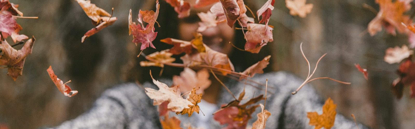 woman throwing maple leaves